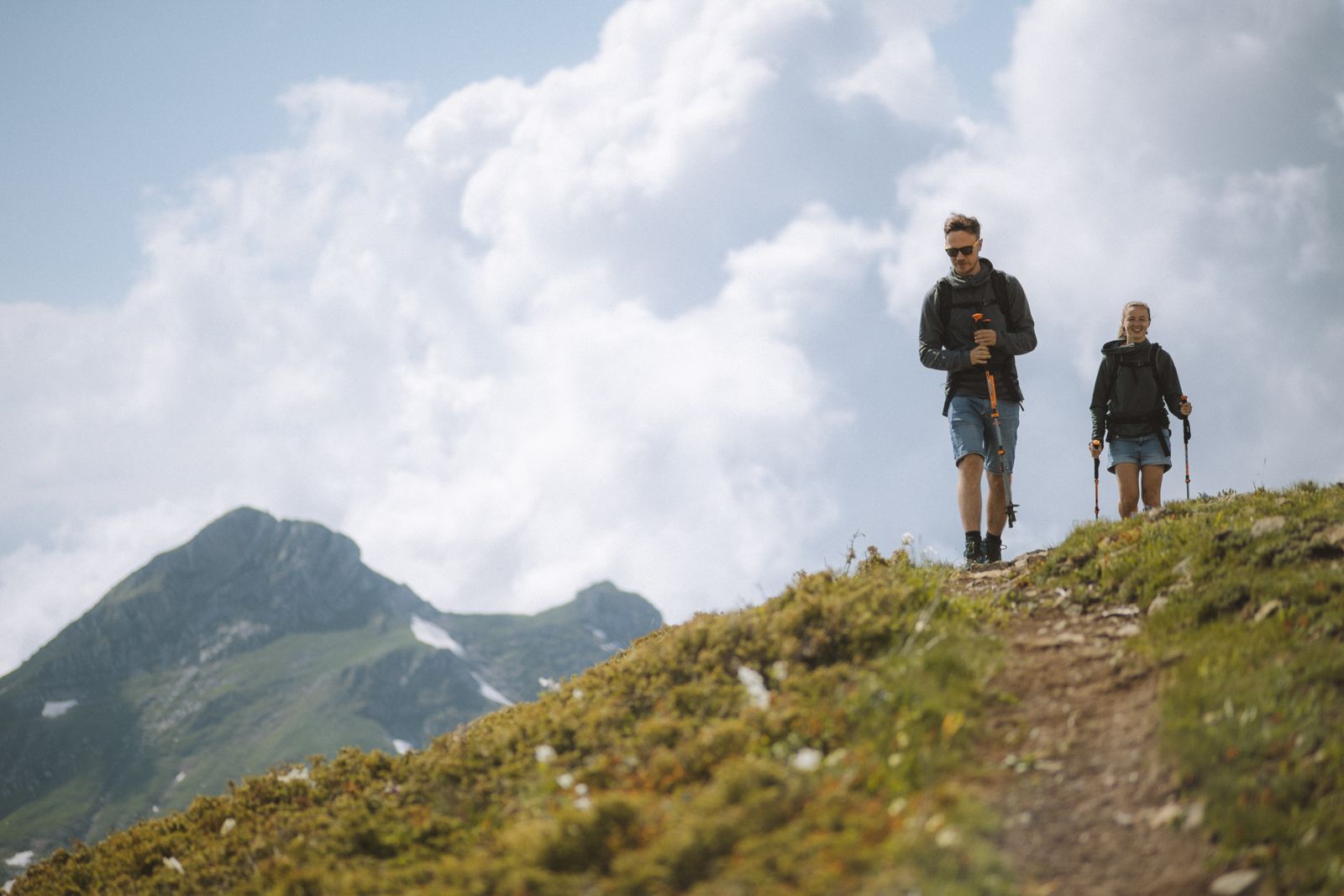 Un couple en randonnée en montagne avec des bâtons de marche