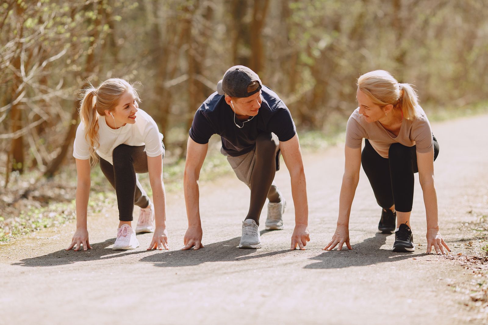 Un groupe de sportifs prêts à sprinter dans un parc